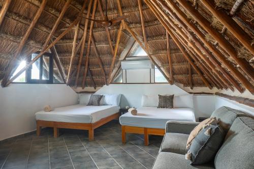 a living room with two beds and a couch at Mantaray Tulum in Tulum