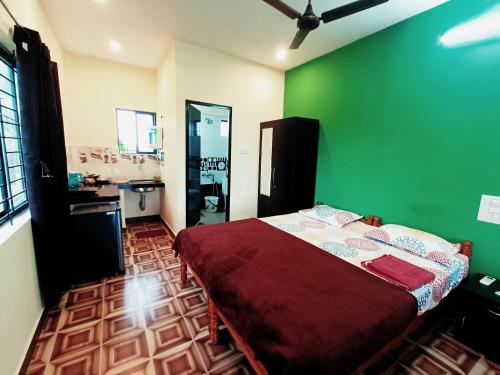 a bedroom with a bed with a green wall at Maanyatha Homestay in Udupi