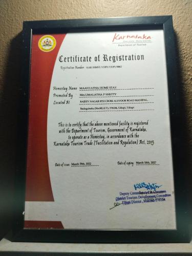 a certificate of registration is posted on a wall at Maanyatha Homestay in Udupi