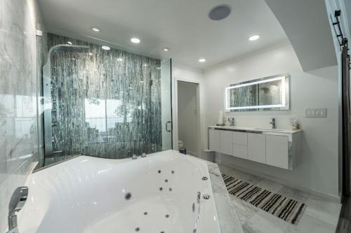 a white bathroom with a tub and a sink at the bachelorette in North Beach
