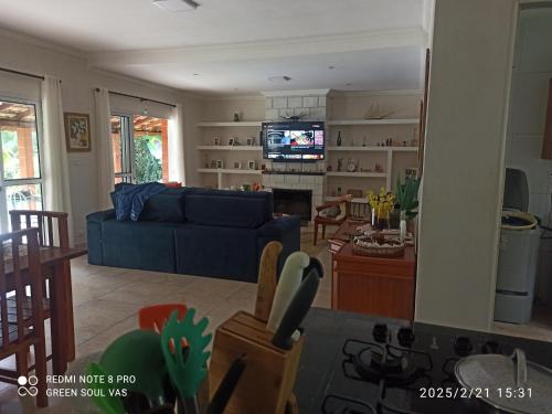 a living room with a blue couch and a tv at Chácara Terra Prometida in Joanópolis