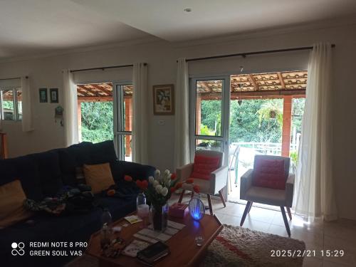 a living room with a couch and a table at Chácara Terra Prometida in Joanópolis