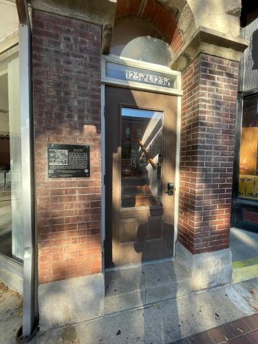 an entrance to a brick building with a revolving door at Stunning Studio Overlooking Main Street Parkade! in Cedar Falls