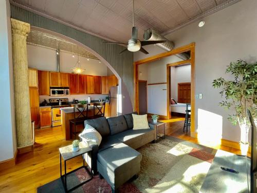 a living room with a couch and a kitchen at Stunning Studio Overlooking Main Street Parkade! in Cedar Falls