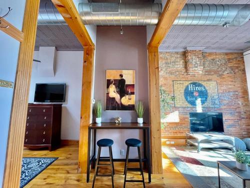 a living room with a table and two stools at Stunning Studio Overlooking Main Street Parkade! in Cedar Falls