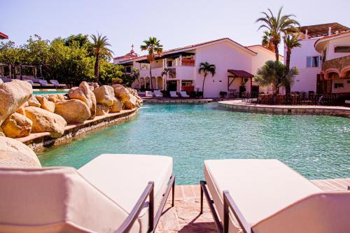 a swimming pool with tables and chairs in a resort at Los Cabos Golf Resort, Trademark Collection by Wyndham in Cabo San Lucas