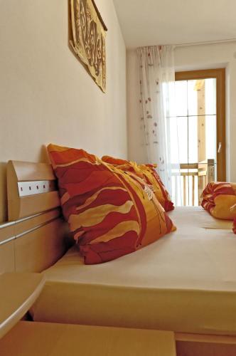 a bed with colorful pillows on it in a room at Roanerhof in San Genesio Atesino