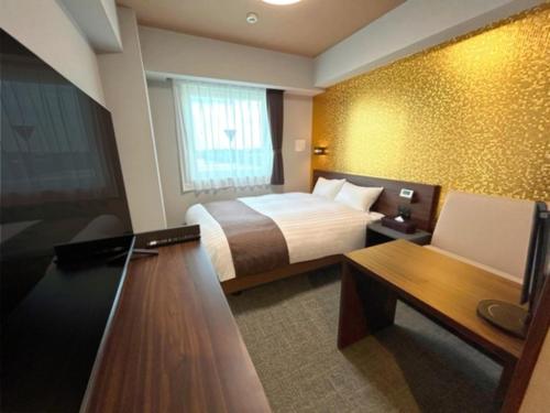 a hotel room with a bed and a desk and a tv at Second Inn Hana Hotel Hanazono Inter - Vacation STAY 40281v in Fukaya
