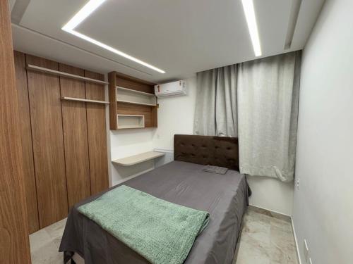 a small bedroom with a bed and a window at Seu apartamento frente mar in Vila Velha
