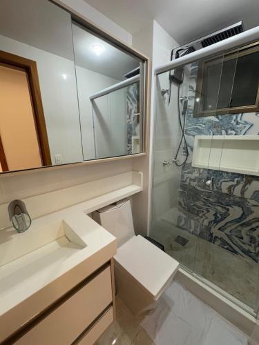 a bathroom with a toilet and a sink and a shower at Seu apartamento frente mar in Vila Velha