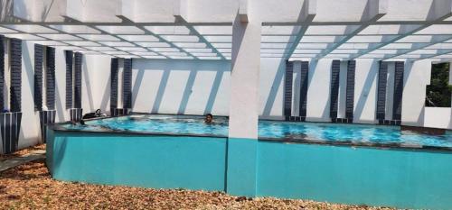 a swimming pool in a building with a blue floor at Akkarai Beach Luxury Beach Villa in Chennai
