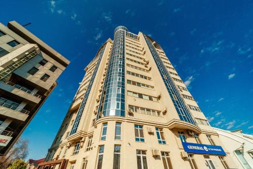 a tall building with a blue sky in the background at The Central Collection Apartments in Chişinău