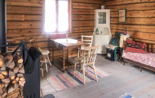 オーケシュバーリアにある1 Bedroom Cozy Home In Åkersbergaのキャビン内のテーブルと椅子付きの部屋