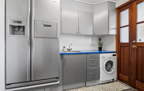 a kitchen with a refrigerator and a washing machine at Beautiful Home In Nibe With Sauna in Nibe