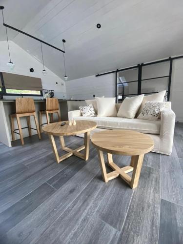 a living room with a couch and two tables at Modo Villa Refugio in Villa La Angostura