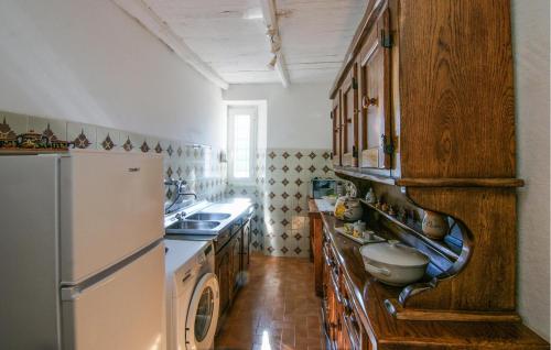 a kitchen with wooden cabinets and a refrigerator at 3 Bedroom Nice Apartment In Stazzema in Stazzema
