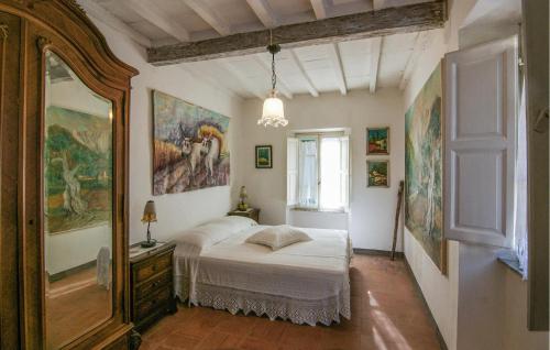 a bedroom with a bed and paintings on the walls at 3 Bedroom Nice Apartment In Stazzema in Stazzema