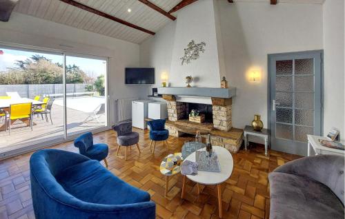 a living room with blue chairs and a fireplace at Villa Avec Piscine Privée in Saint-Jean-de-Monts