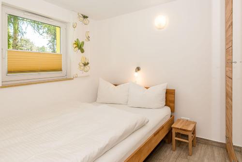 a small bedroom with a bed and a window at Bungis - 28 Ferienhäuser Am Grimnitzsee G3 in Joachimsthal