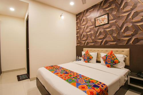 a bedroom with a large bed with a wall at Hotel Rosewood Inn in Amritsar
