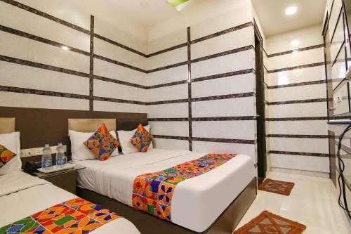 two beds in a room with striped walls at Hotel Rosewood Inn in Amritsar