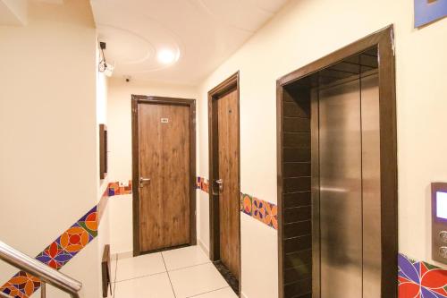a hallway with two wooden doors and stairs at Hotel Rosewood Inn in Amritsar