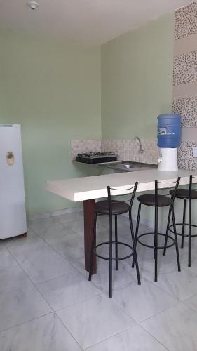a kitchen with a table with chairs and a sink at Kitipê Arretado da Peste in Aquiraz