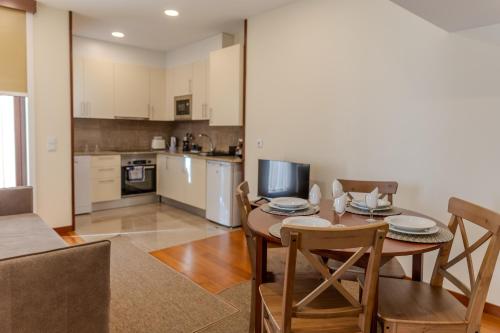 a kitchen and dining room with a table and chairs at Cabo do Mar Apart.- Sereias Beach in Espinho