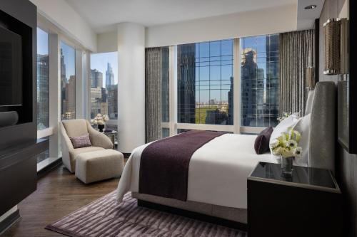 a bedroom with a bed and a view of the city at Mandarin Oriental, New York in New York