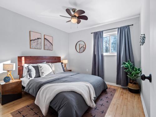 une chambre avec un lit et un ventilateur de plafond dans l'établissement Hot Tub, Game Room, 4 Bedrooms, Gorgeous Remodel, à Akron
