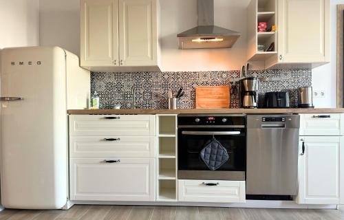 a kitchen with white cabinets and a refrigerator at Fischerhus in Rieseby