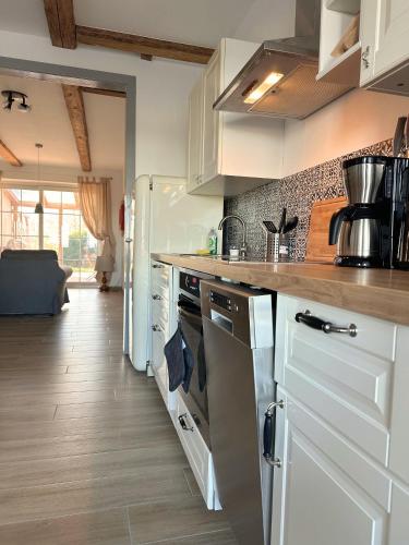 a kitchen with white cabinets and stainless steel appliances at Fischerhus in Rieseby