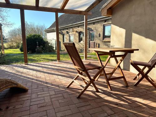 a wooden table and two chairs on a patio at Fischerhus in Rieseby