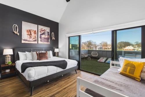 Un dormitorio con una cama y una ventana grande. en TWO Adjacent Homes Sleeps 24 Only 3 miles to Broadway, en Nashville