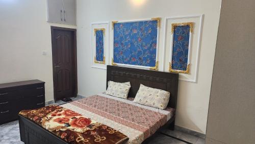 a bedroom with a bed and two windows at Darul Khair in Lahore