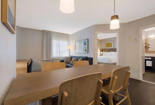 a dining room and living room with a table and chairs at Sonesta Simply Suites Baltimore BWI Airport in Linthicum Heights