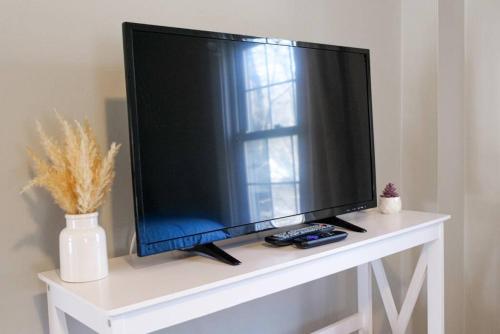 a flat screen tv sitting on top of a white table at Large 4 Bedroom Home Close to Airport and IX Center in Berea