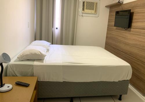 ein Schlafzimmer mit einem Bett und einem Schreibtisch mit einem Fernseher in der Unterkunft Apto 250m da praia em Ponta Verde I Piscina I Garagem 709 in Maceió