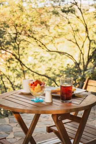 uma mesa de madeira com uma taça de fruta e uma bebida em Hotel Cactus Taganga em Taganga