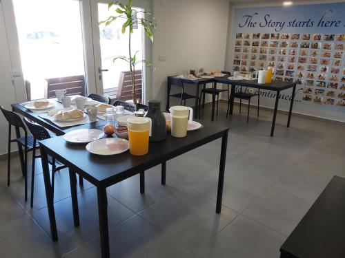 ein Speisesaal mit Tischen, auf denen Speisen und Getränke stehen in der Unterkunft Zambeachouse - Hostel Paradise in Areia Branca