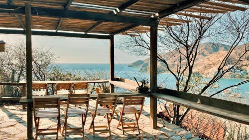 einen Tisch und Stühle auf einer Veranda mit Meerblick in der Unterkunft Hotel Cactus Taganga in Taganga