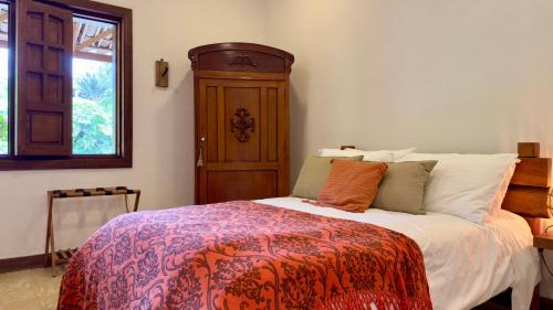 a bedroom with a bed and a wooden cabinet at Hotel Mandalay 1941 in Pereira