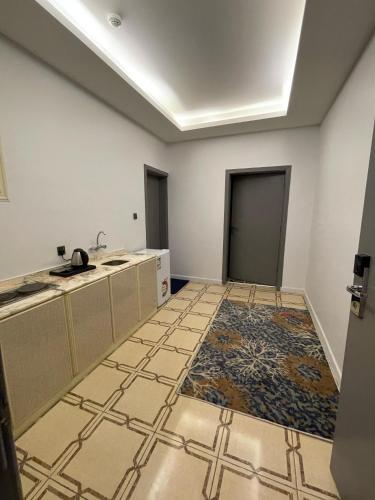 an empty kitchen with a sink and a tile floor at كــيــان الـمـنـسـك Kayan Al Mansak in Abha