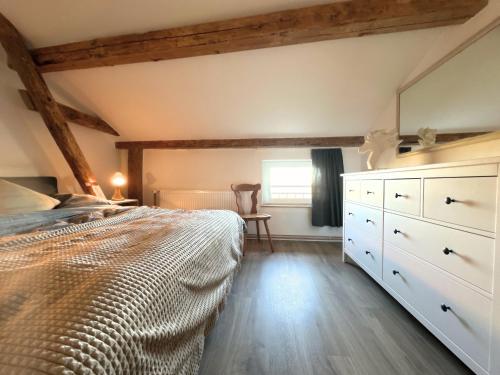 a bedroom with a bed and a dresser and a window at Fischerhus in Rieseby