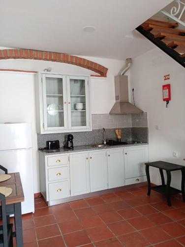 a kitchen with white cabinets and a sink at Casa da Talha By Viva a Vida - Alojamentos & Hotels in Constância