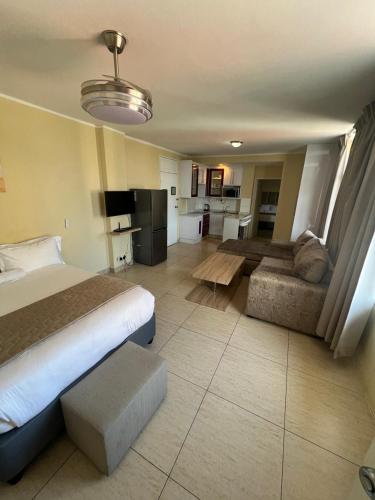 a hotel room with a bed and a couch at Oceanic 108 in Durban