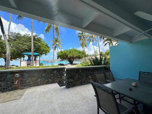 a patio with a table and chairs and the ocean at Secret Harbour Beach Resort in St Thomas