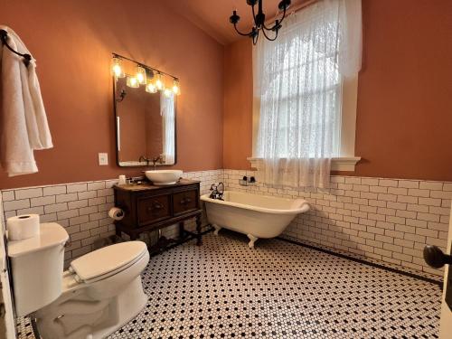 a bathroom with a toilet and a tub and a sink at The Myrtles in Saint Francisville
