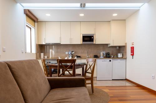 a kitchen with a couch and a table in a room at Cabo do Mar Apart.- Baía Beach in Espinho