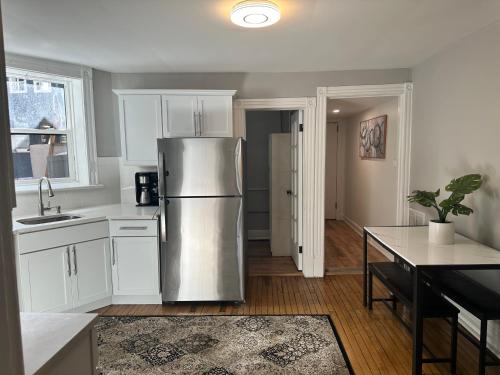 a kitchen with a stainless steel refrigerator and white cabinets at The Lyons' Lair in Chicago